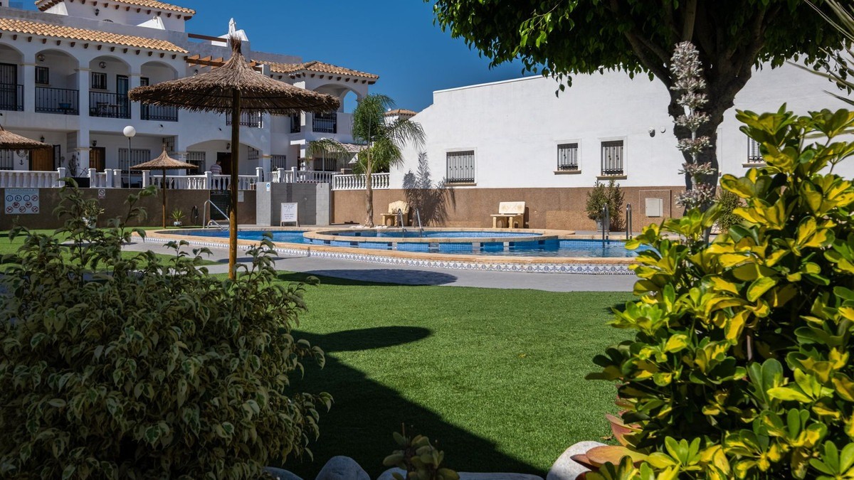 Located in a pleasant residential complex with a communal pool, this charming single-story bungalow