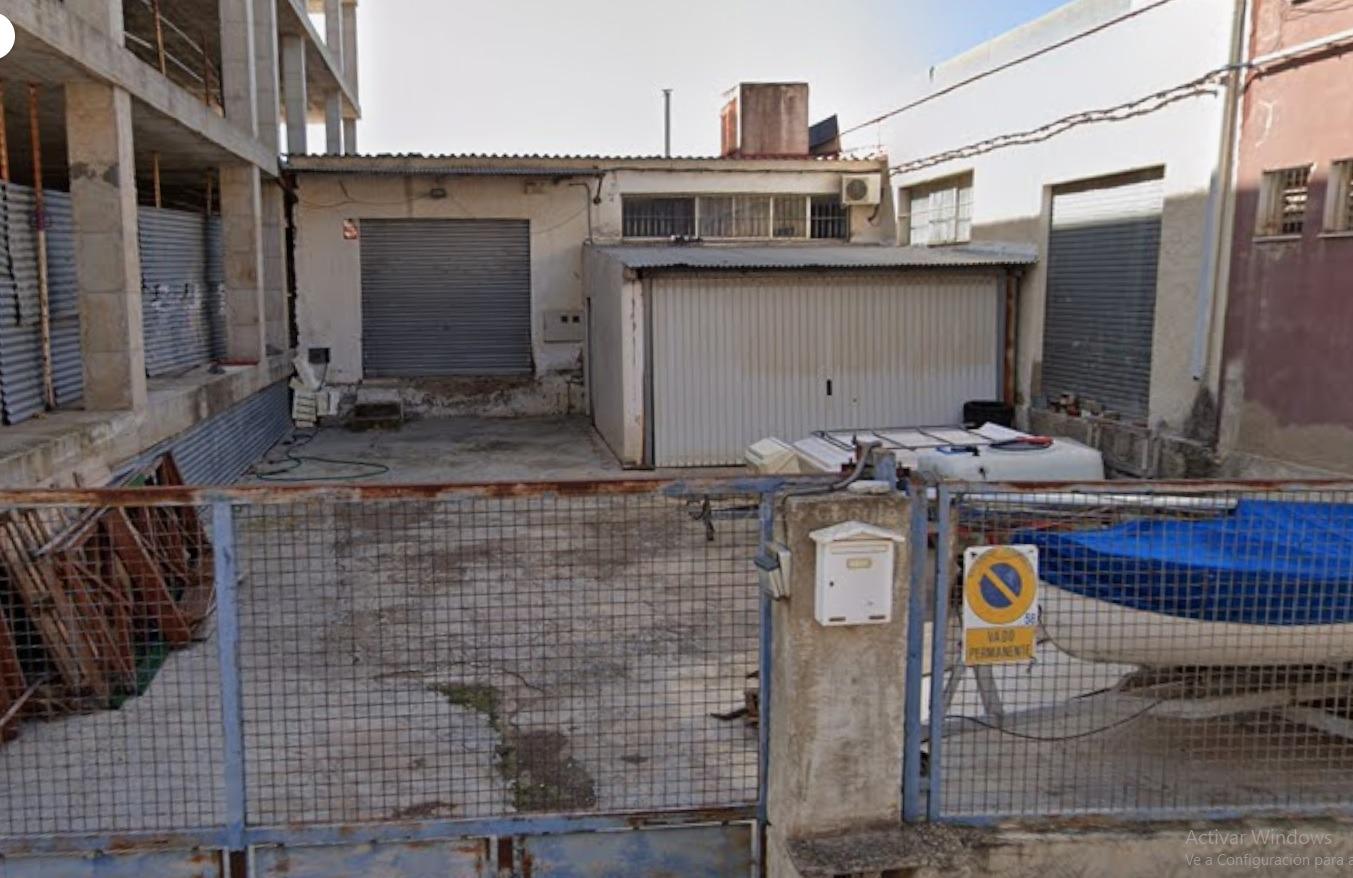 An industrial warehouse with 182 m² of built area is offered for sale, located on a 304 m² fully fen