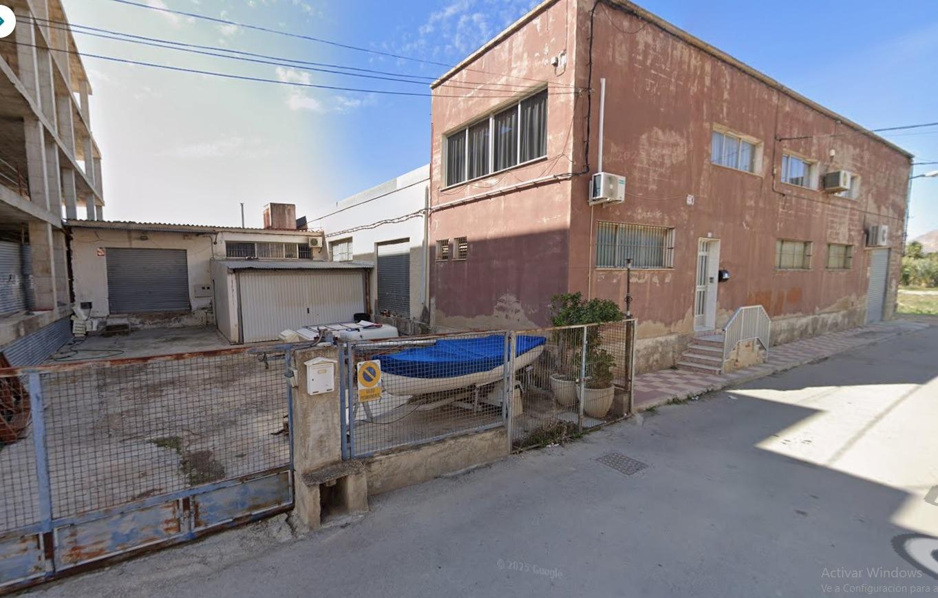 An industrial warehouse with 182 m² of built area is offered for sale, located on a 304 m² fully fen