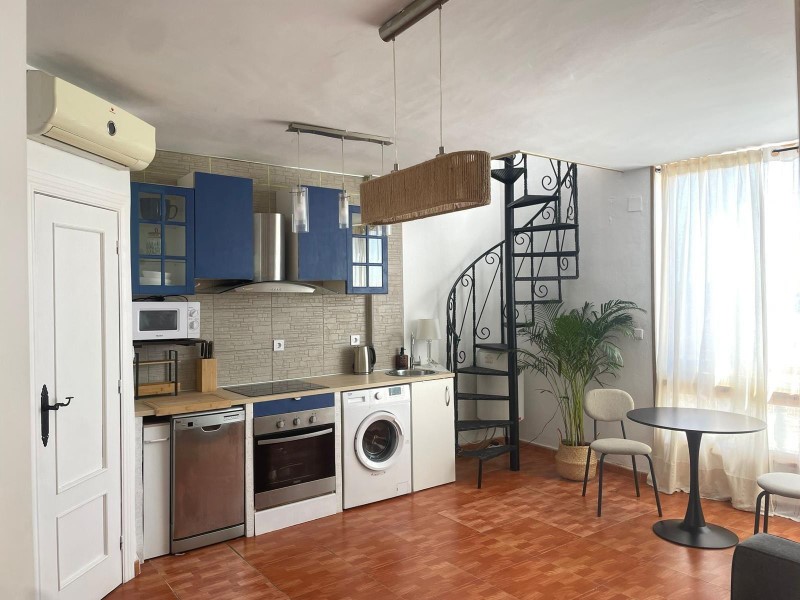 This charming two-bedroom penthouse, located on the first floor of a building without a lift, offers