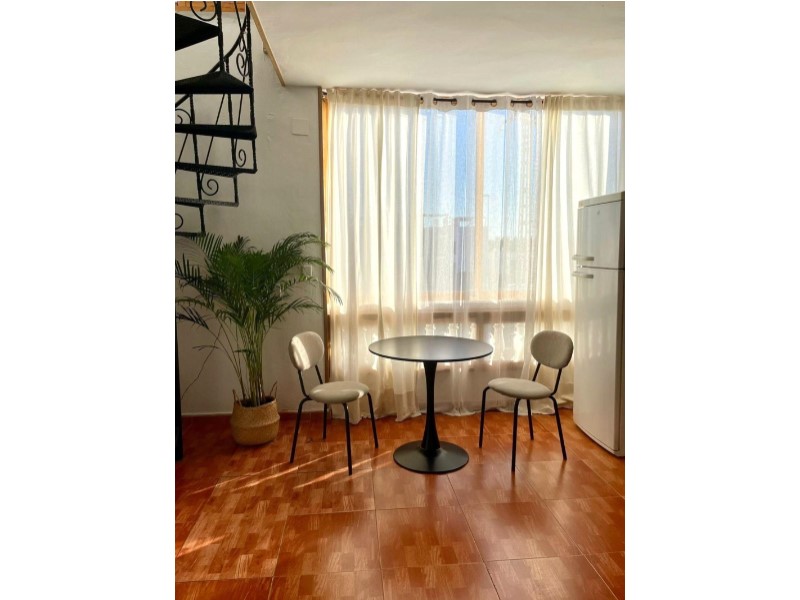 This charming two-bedroom penthouse, located on the first floor of a building without a lift, offers